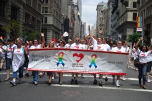 Volunteers and team members participate in annual Pride parade.