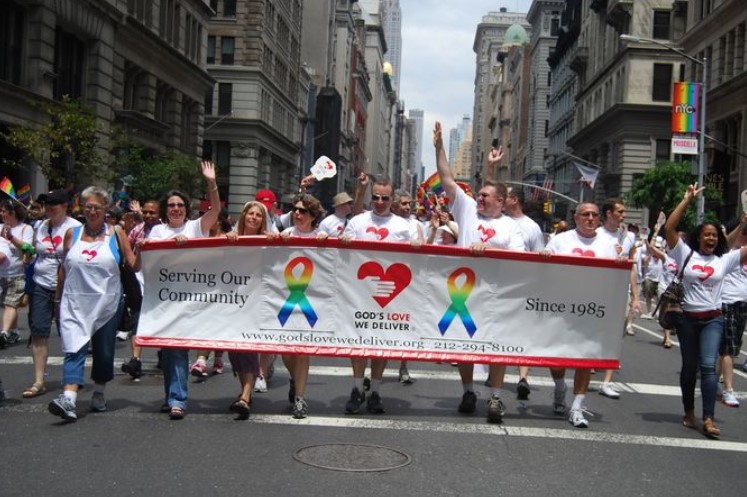 Volunteers and team members participate in annual Pride parade.